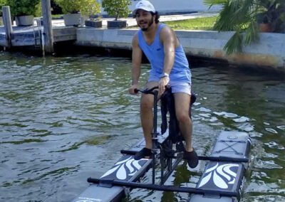 Men riding a water bike through a water canal - miami-waterbikes.com